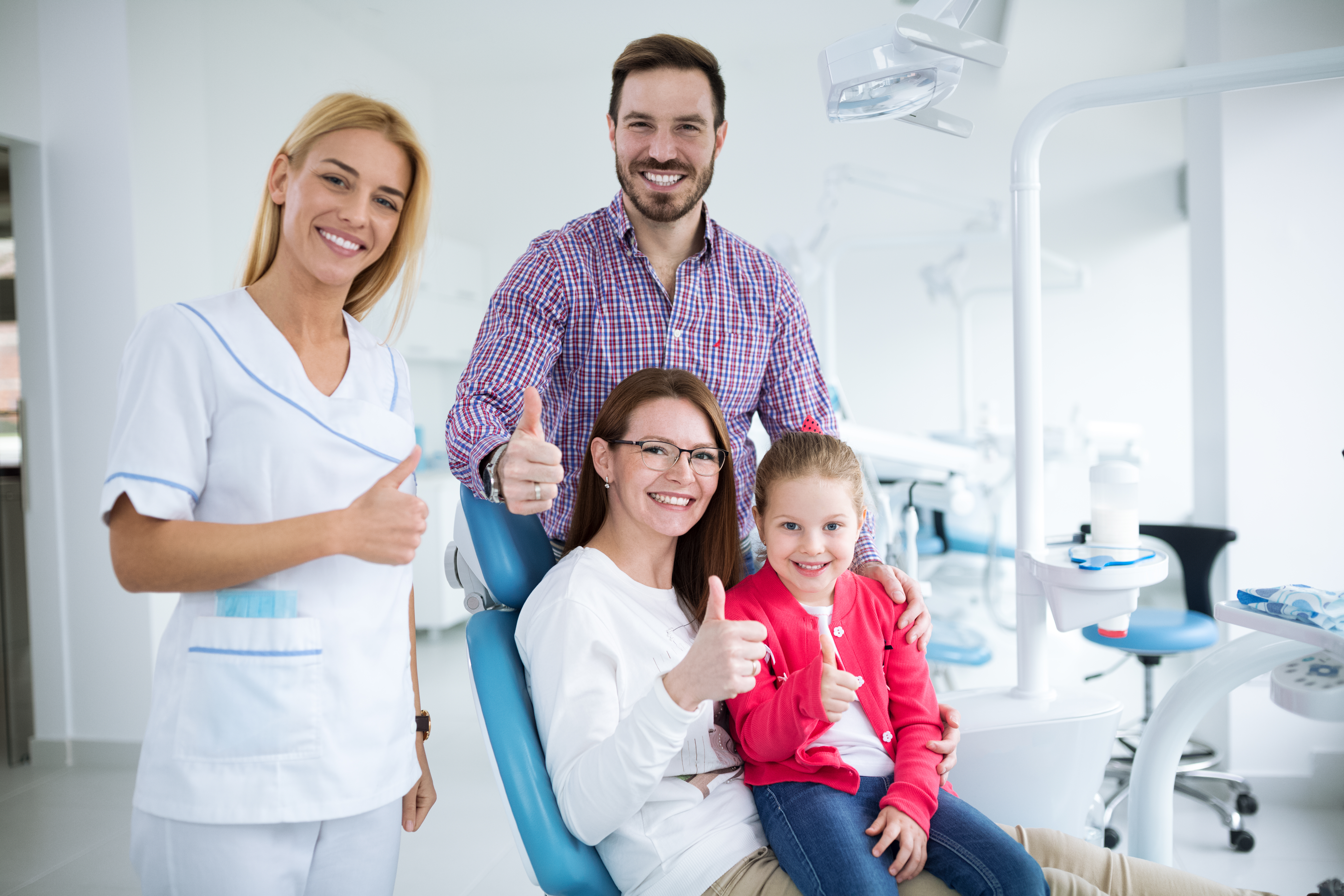 Happy family with a smiling young dentist in a dental office